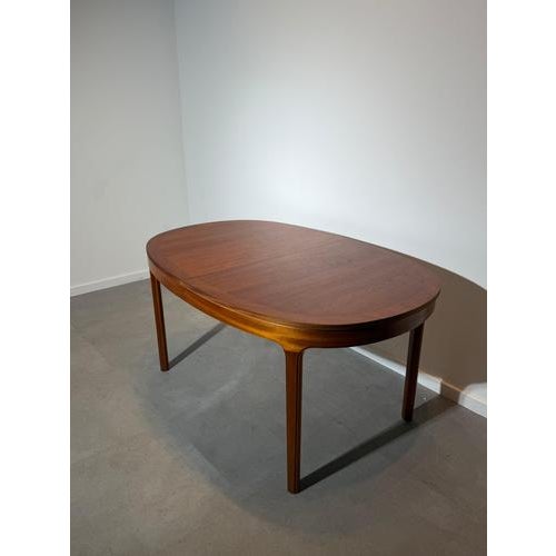 A beautifully crafted mid-century modern dining table by Nathan Furniture, executed in warm teak and featuring an elegant...