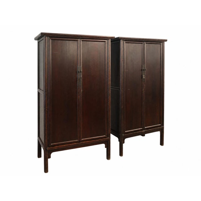 This tall 19th century antique cabinet features a clean-lined design with a rich, dark brown finish that highlights the...