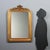 A carved and gilded wooden mirror dating back to the late 19th century, from Italy. The frame features a richly crafted...