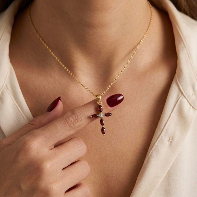 Infuse your style with timeless grace and vibrant warmth in this exquisite Marquise Garnet Cross Necklace. This delicate...