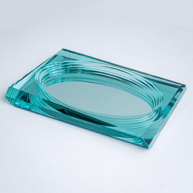 Turquoise glass bowl or centerpiece in a rectangular shape. The bowl is faceted on the outer edge and forms an oval with a...