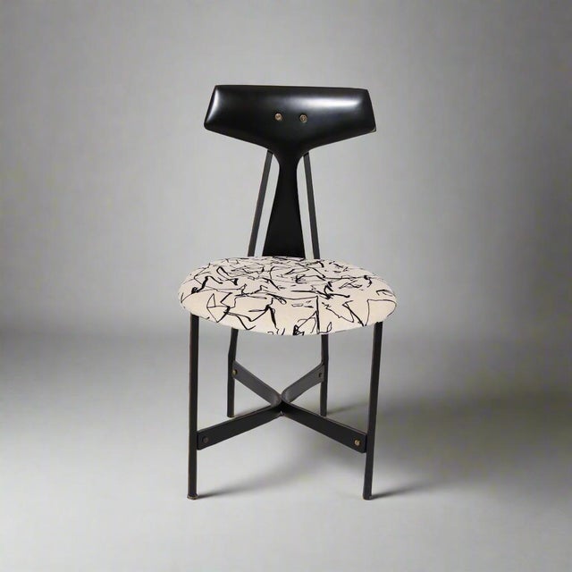 A set of four modernist side chairs in ebonized wood and black metal.
