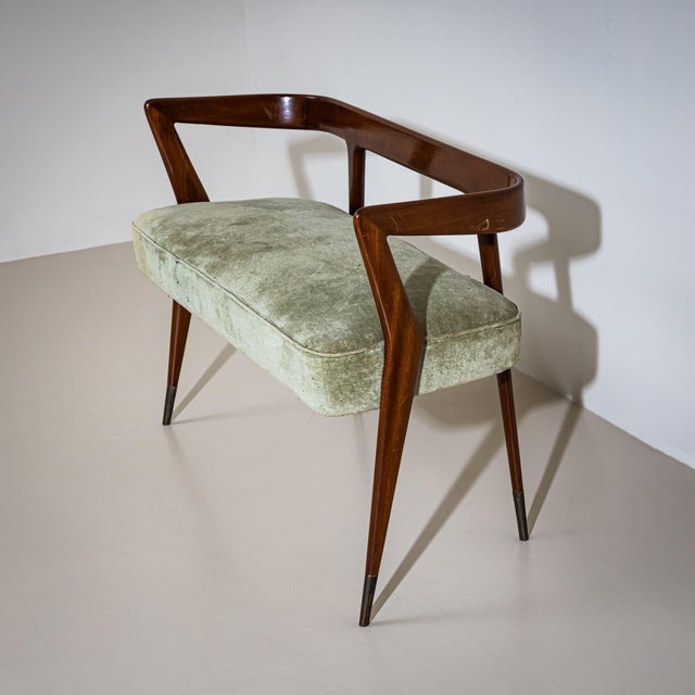 Light and elegant bench with an upholstered seat and slender frame. The tapered legs are fitted with brass sabots, and a...