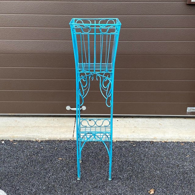 A unique mid century metal plant stand with an old bright blue enameled finish. One piece welded construction. Top shelf...