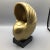 Composite material gold shell on a composite black base.