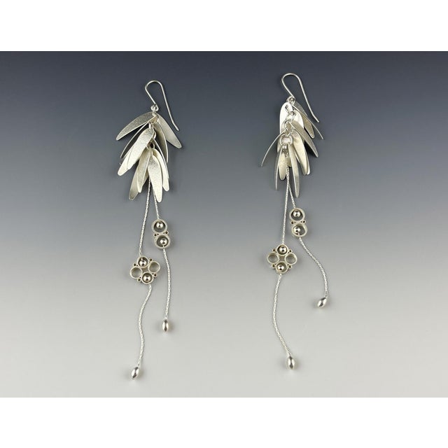 Sterling silver pixie dust trails shimmering wings of hand-embossed and riveted sterling silver. Handmade by American...