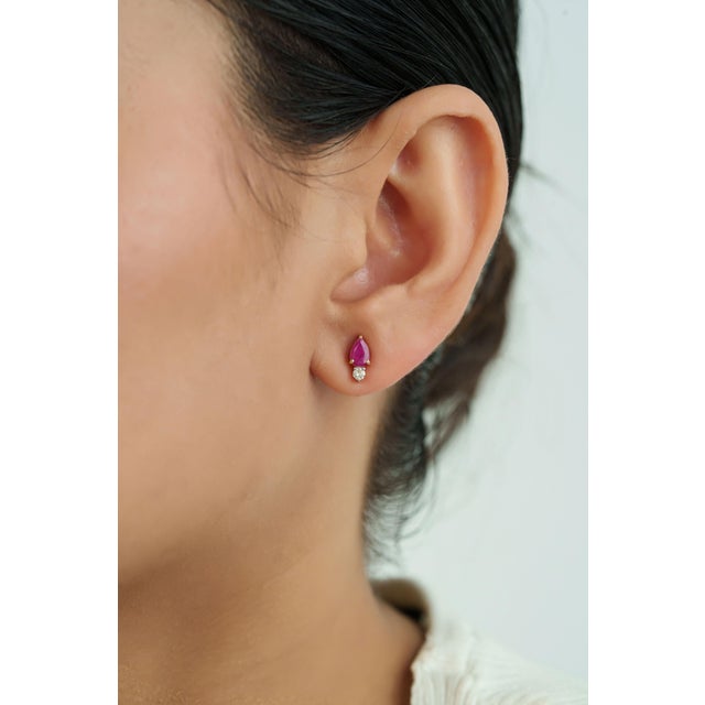 These stud earrings feature a 1ct of pear-shaped ruby set, in 14k yellow gold. Each ruby measuring 6 x 4 mm in size and...