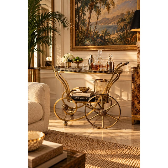 Stunning vintage 1960s Italian Hollywood Regency bar cart featuring an elegant gold brass frame with graceful scrolling...
