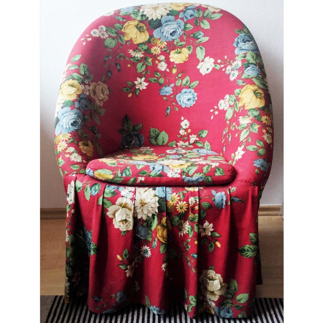 Charming 1960s soft padded rattan chair upholstered in a lovely red floral cotton fabric with a pleated skirt and sturdy,...