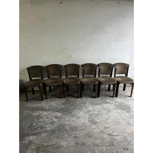 A set of six vintage dining chairs from the late 1970s–1980s, featuring elegantly curved backs, solid wood frames and...