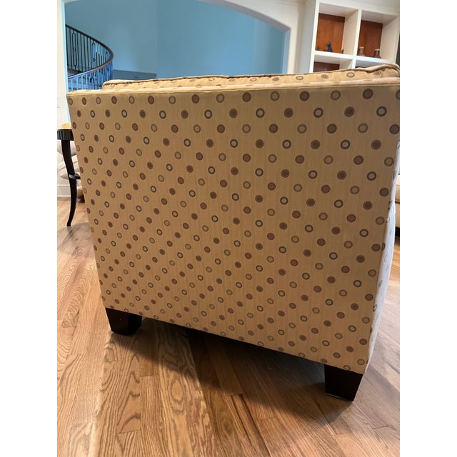 This cheerful and comfortable upholstered club chair has a yellow fabric base featuring a multi-colored polka dot pattern....