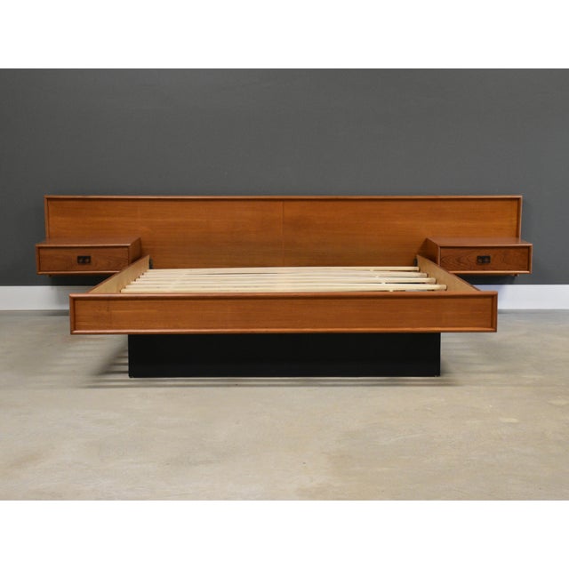 A mid century modern teak queen size floating platform bed with floating nightstands and black finger pulls. Made in...