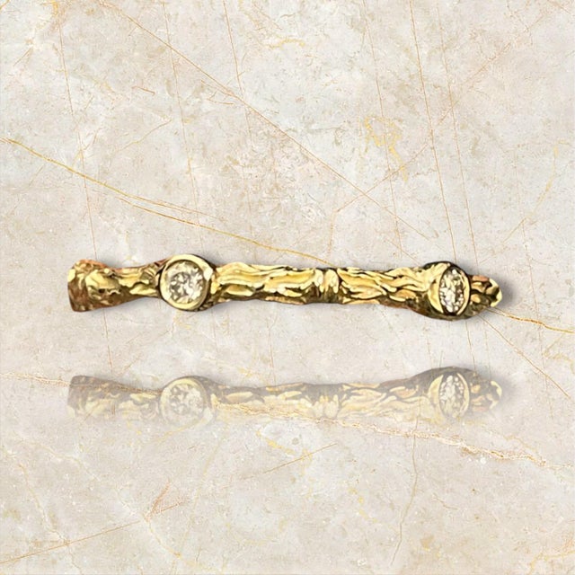 This exquisite 14K gold band features a nature-inspired textured design, beautifully complemented by sparkling diamonds....