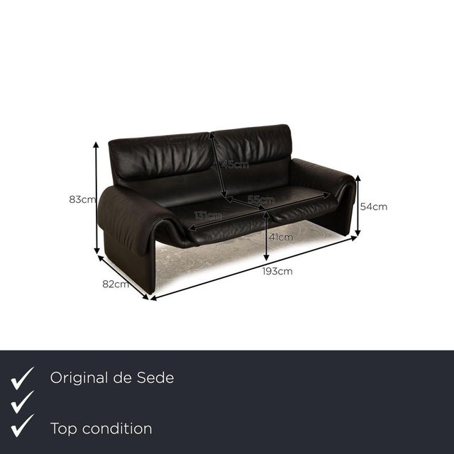 The two -seater DS 2011 by de Sede is covered with a black real leather and stands on unobtrusive feet. It is...