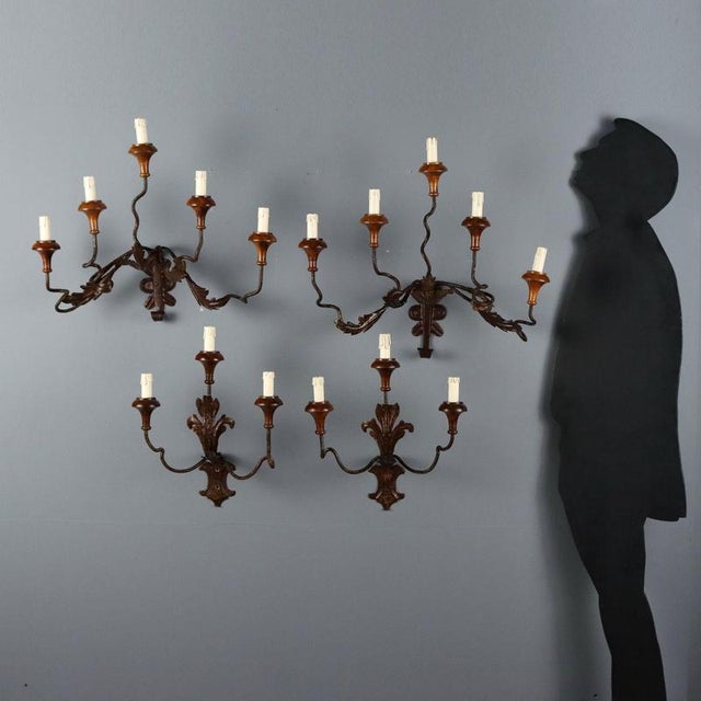 A group of four wall sconces in wrought iron and sheet metal with leaf-like patterns, made in italy in the late 19th...
