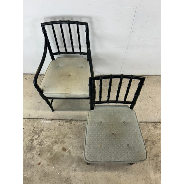 This set of four dining chairs feature hardwood frames with original black paint, caned wicker seats and removable tufted...