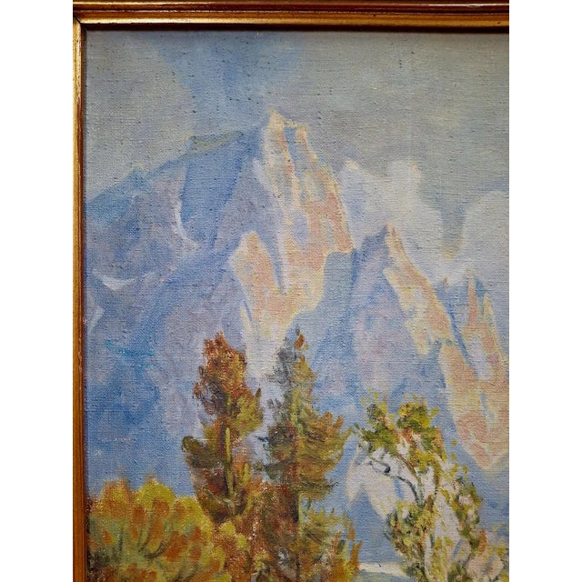 Snow-topped jagged peaks reflected in a mountain lake come together in this ethereal landscape painting by noted American...