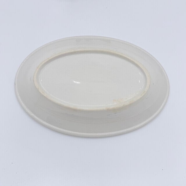 A charming piece of vintage American hotelware, this petite oval platter pairs classic blue-and-white china with a...