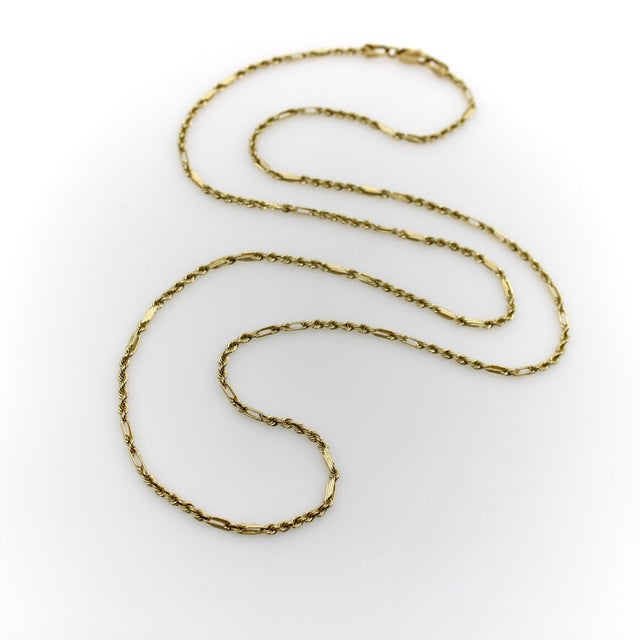 We love this unusual combination of rope chain and twisted bar link seen in this vintage 14k gold chain. The bar links are...