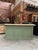 This old shop counter has been completely restored. Its body has a green patina finish and its top is made of raw wood. At...