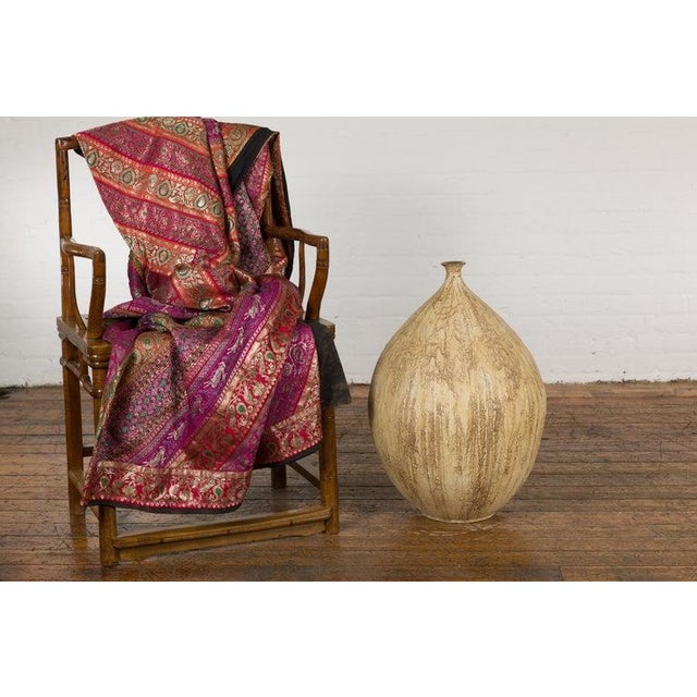 A contemporary Prem Collection artisan hand crafted ceramic vase with narrow mouth, mustard glaze and textured effects....