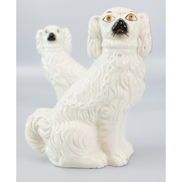 A fine pair of antique 19th Century English Staffordshire white spaniel mantel dog figurines. These charming dogs are hand...