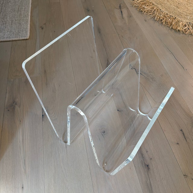 Wave inspired thick acrylic magazine/book rack by Interlude Home. Minimalist and sophisticated storage.