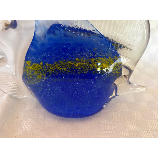 A beautiful hand blown Murano glass fish. It is a dark blue with gold detailing across the body of the fish. The fins and...