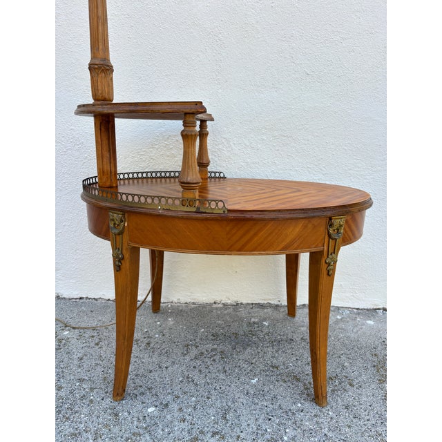 Antique French Louis XVI-style etagere tiered side table featuring a built-in brass floor lamp, circa late 19th century....