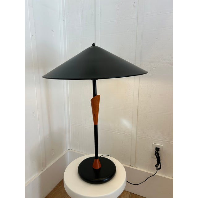 Vintage postmodern table lamp with black metal cone shade and sculpted wood accent. Features a circular black base and...