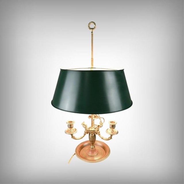 An elegant bouillotte lamp in gilt bronze and brass, featuring three beautifully sculpted dolphin arms. At its center, the...