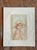 This vintage lithograph presents a quietly contemplative portrait of a young girl in a soft, wide-brimmed hat, her head...