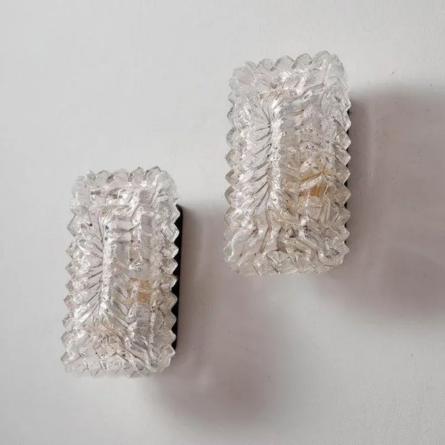 German wall lamp from the 1970s produced by Wila. The glass shade of the wall lamp has a textured pattern and a charming...