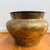 A sculptural antique brass vessel with the kind of timeworn surface that simply cannot be replicated. This substantial...