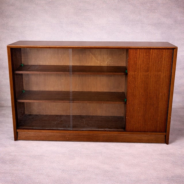 Mid-Century Teak Sliding Door Bookcase with Glass Front by Herbert Gibbs, 1970s, in Very Good conditions. Designed 1970 to...