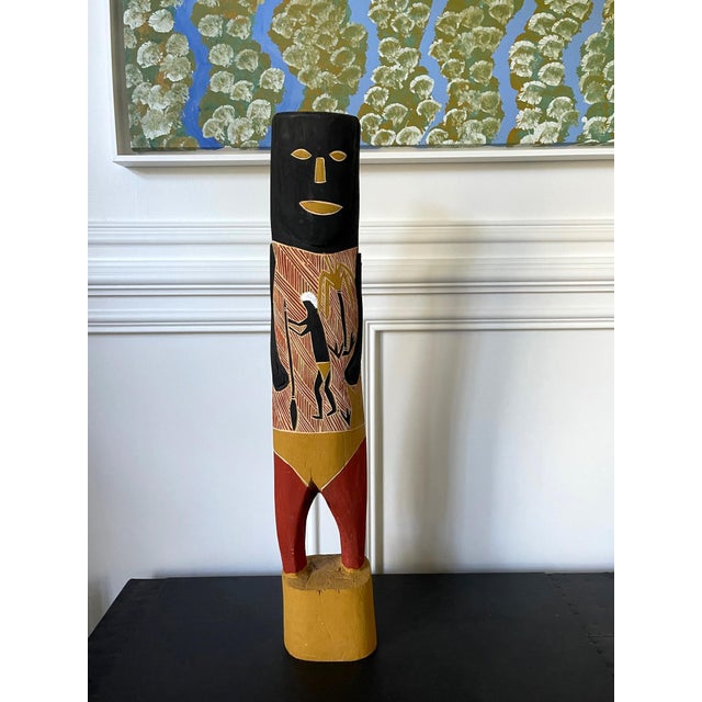 Hand-carved wood ancestor figure with surface pictorial carving showing kangaroo hunting and decorated with black and red...