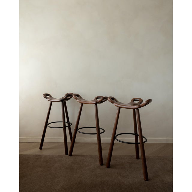 A vintage set of marbella bar stools in stained solid wood and black metal, made by confonorm and produced in spain during...