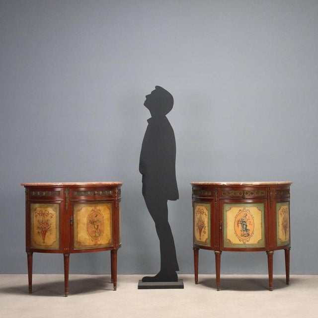 A pair of neoclassical-style half-moon mahogany sideboards. Different marble tops, a front with a drawer and a central...