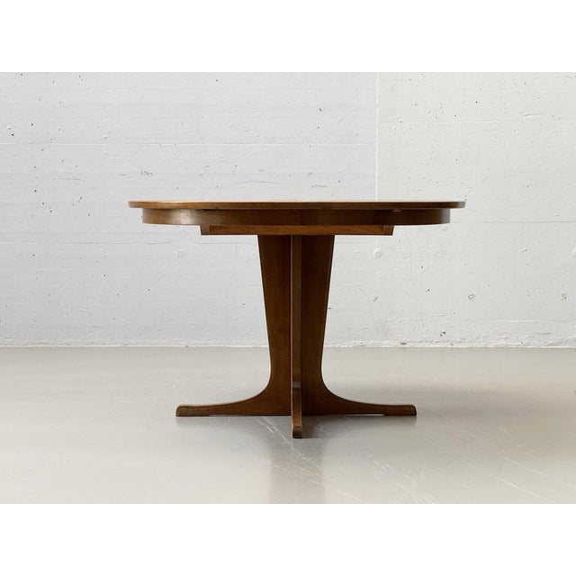 This elegant round table from the 1960s impresses with its harmonious design and high-quality craftsmanship in warm...