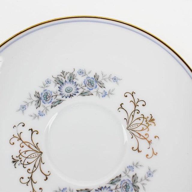 A pretty porcelain white saucer with blue and gold detail by Noritake. This beautiful plate has a painted blue and gold...