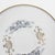 A pretty porcelain white saucer with blue and gold detail by Noritake. This beautiful plate has a painted blue and gold...
