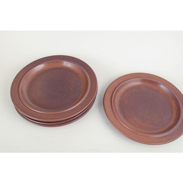 Arabia Finland Plates “Ruska”, 1960/70s. Four dinner plates in dark brown stoneware from Arabia’s iconic “Ruska” series,...