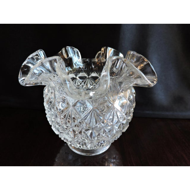 This crimped vase was made by the Fenton Art Glass Co. and it is pressed glass pressed in their Fine Cut Block pattern...