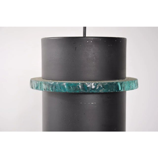 This pendant lamp was manufactured by Hiemstra Evolux in the 1960s. It is made from black metal with a glass ring that...