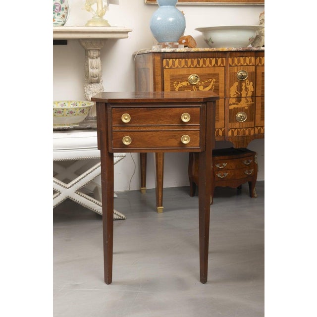 This is one of a pair of elegant identical English George III-style mahogany side table featuring a clean, refined...