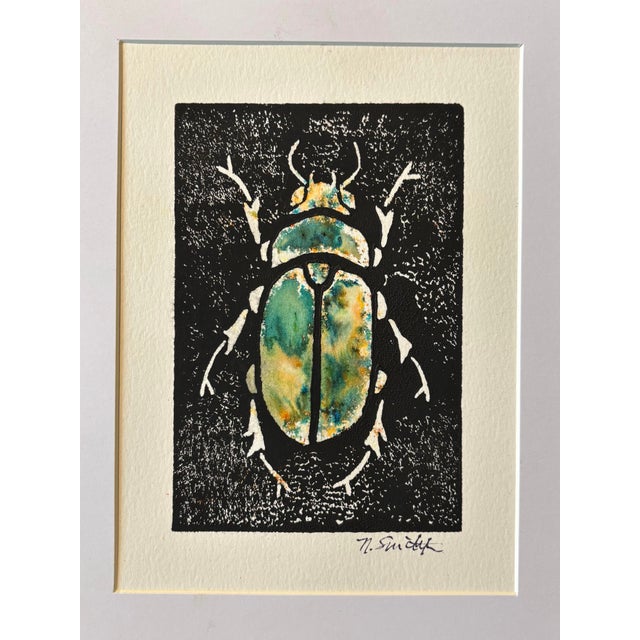 An original hand-carved block linocut featuring a detailed beetle motif, individually printed with black ink and finished...