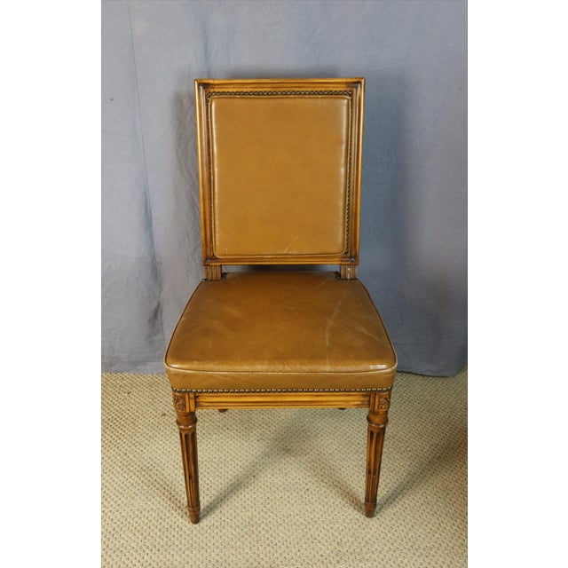 Set of six beechwood chairs upholstered in havana leather with piping. These chairs are from the 20th century and are in...