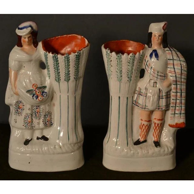 This is a large antique pair of late 19th century Scottish figures, with nicely detailed costumes and holding spill vases....