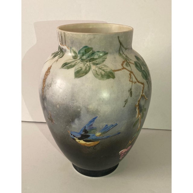 Delicately hand painted opaline glass urn shape vase. Branches of wisteria, a blue jay and butterfly depicted on an ombre...