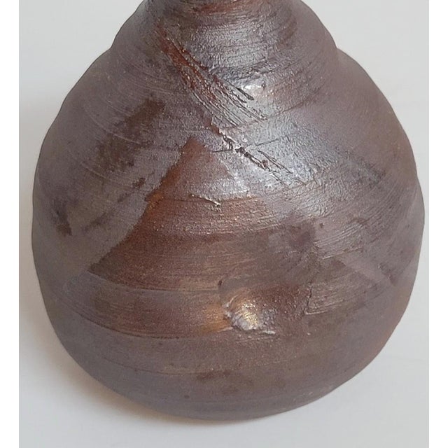 A signed Japanese studio pottery bud vase in the Bizen tradition, hand thrown from iron-rich stoneware with an unglazed...